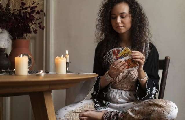 Femme réalise de la divination avec des cartes tarot