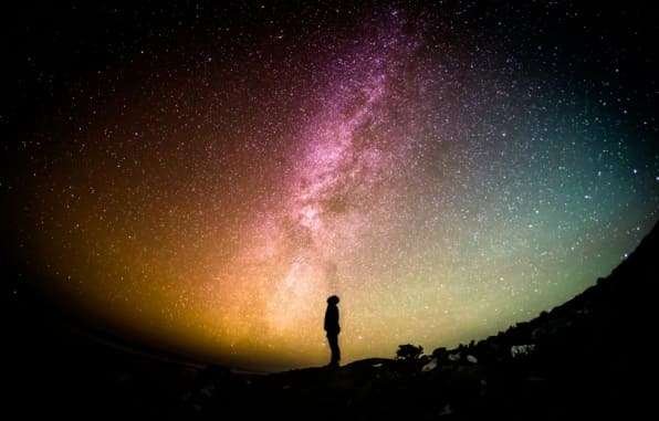 Homme qui regarde les étoiles et augmente son taux vibratoire